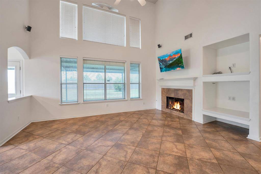 Bright and inviting family room with natural light, a cozy fireplace, and ample space to relax.