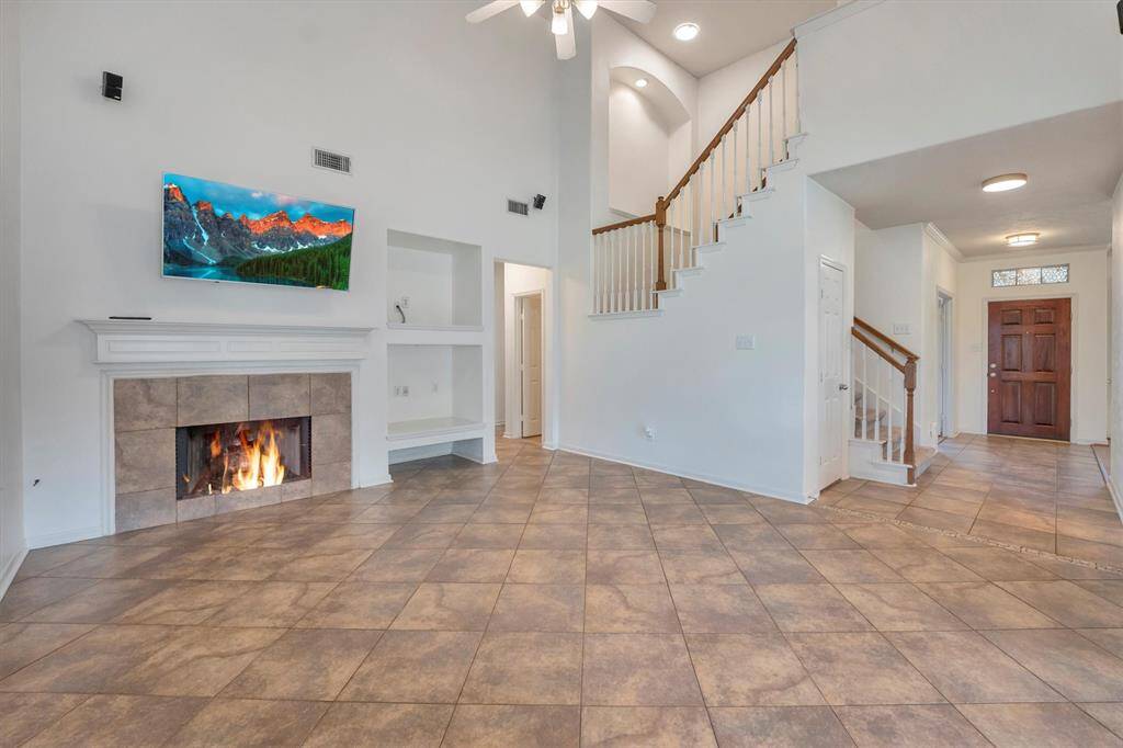 The family room is bright and welcoming, featuring abundant natural light, refreshed paint, tile flooring, cozy fireplace as the focal point. Whether you're cozied up for a movie night or simply gazing out at your backyard oasis, this space was made for relaxing