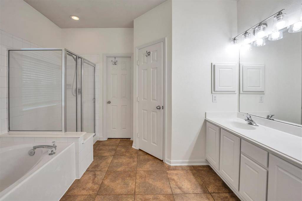 Indulge in the luxurious primary bath featuring dual sinks, a soothing soaking tub, and a sleek standalone shower.