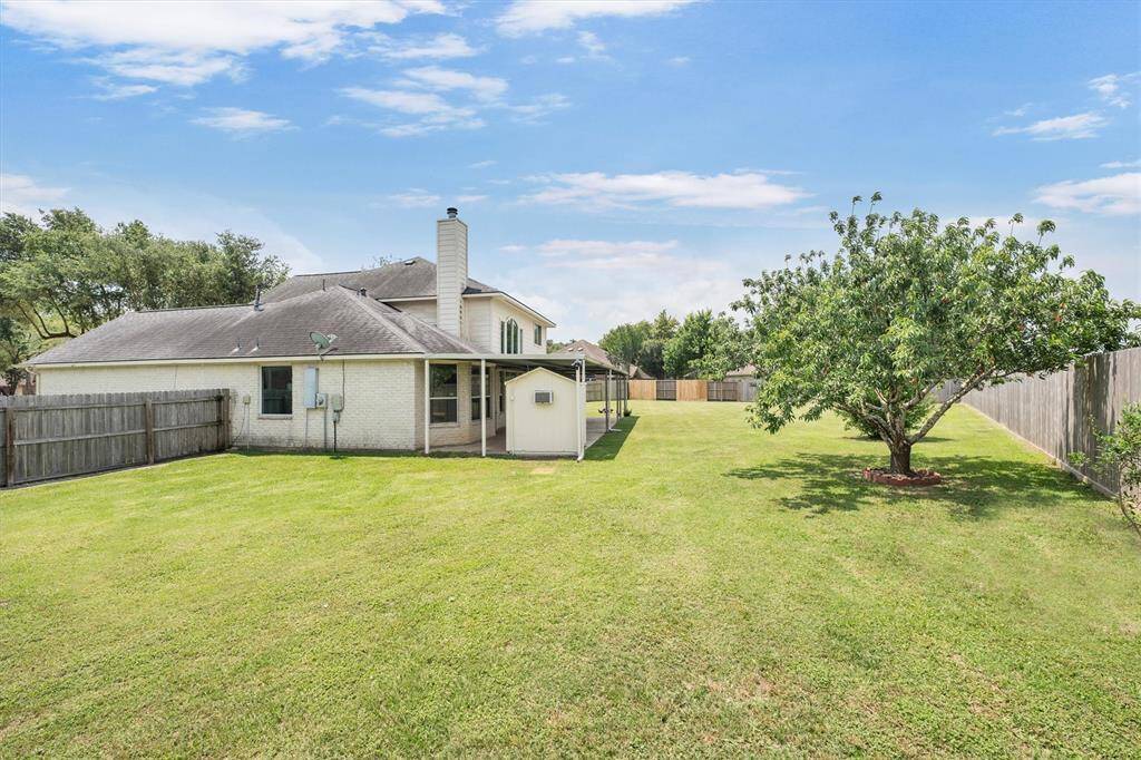 Spacious backyard with a covered patio, a storage shed and plenty of room for outdoor activities and relaxation.
