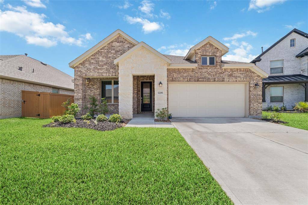This charming single-story brick home features a neatly landscaped front yard, a two-car garage, and a welcoming entryway with a covered front porch.