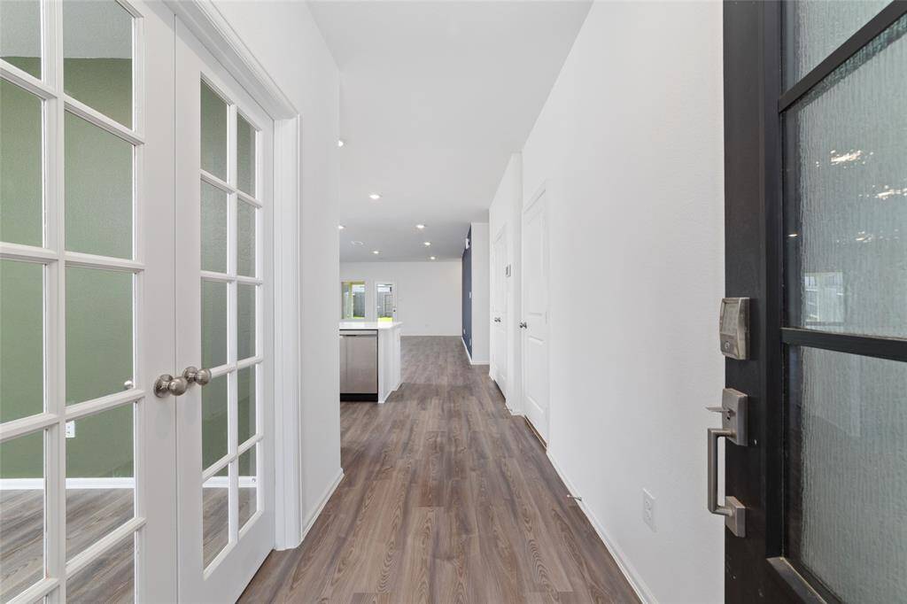 Welcome in! This bright, inviting entryway with elegant luxury vinyl plank flooring, opens right up to the spacious, wide open floor plan! To the left, the french doors lead to a convenient study!