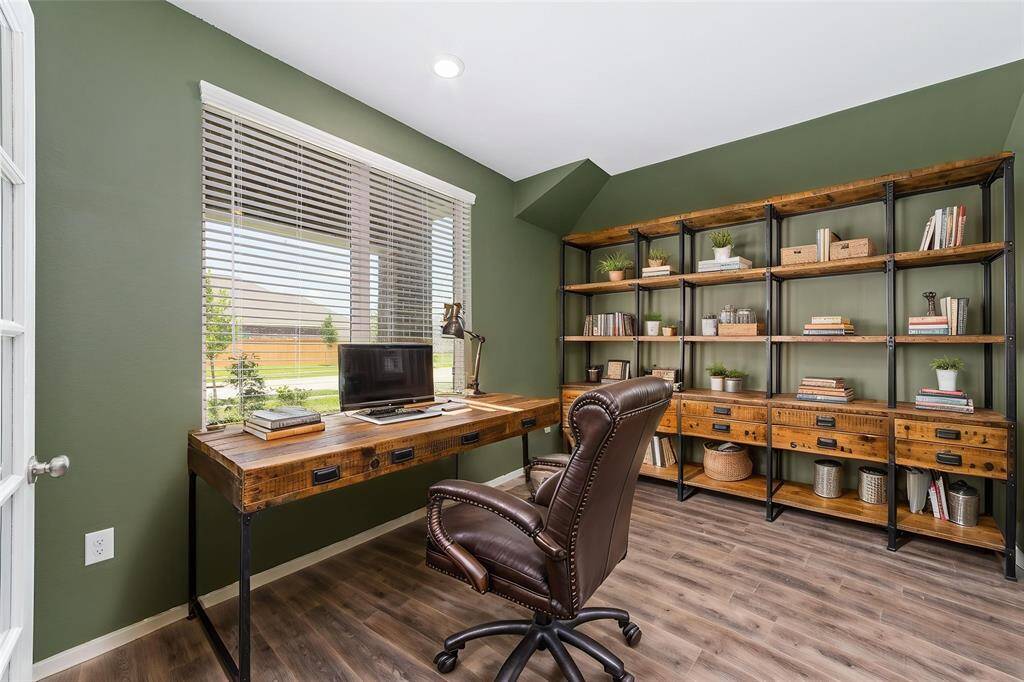 The study features trendy green walls, a large window that floods the space with natural light, creating the perfect space for creativity and productivity.
