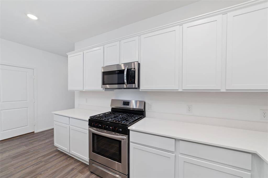 Stainless steel appliances, including a gas range and microwave vent hood combo that vents to the exterior.
