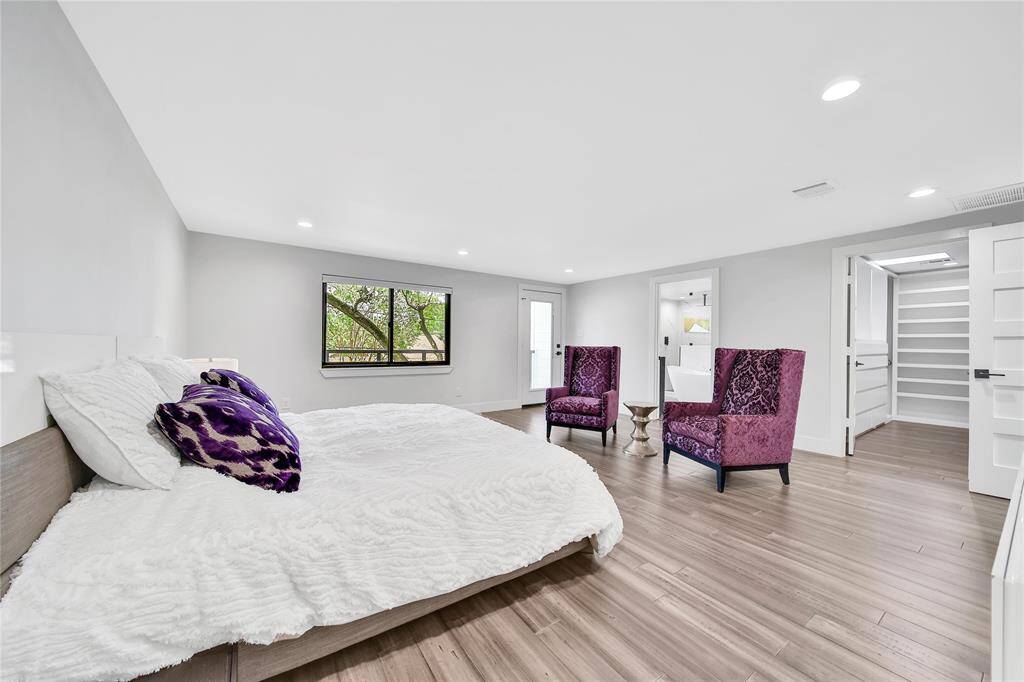 Upstairs primary suite with large walk-in closet and ensuite bathroom and balcony access.