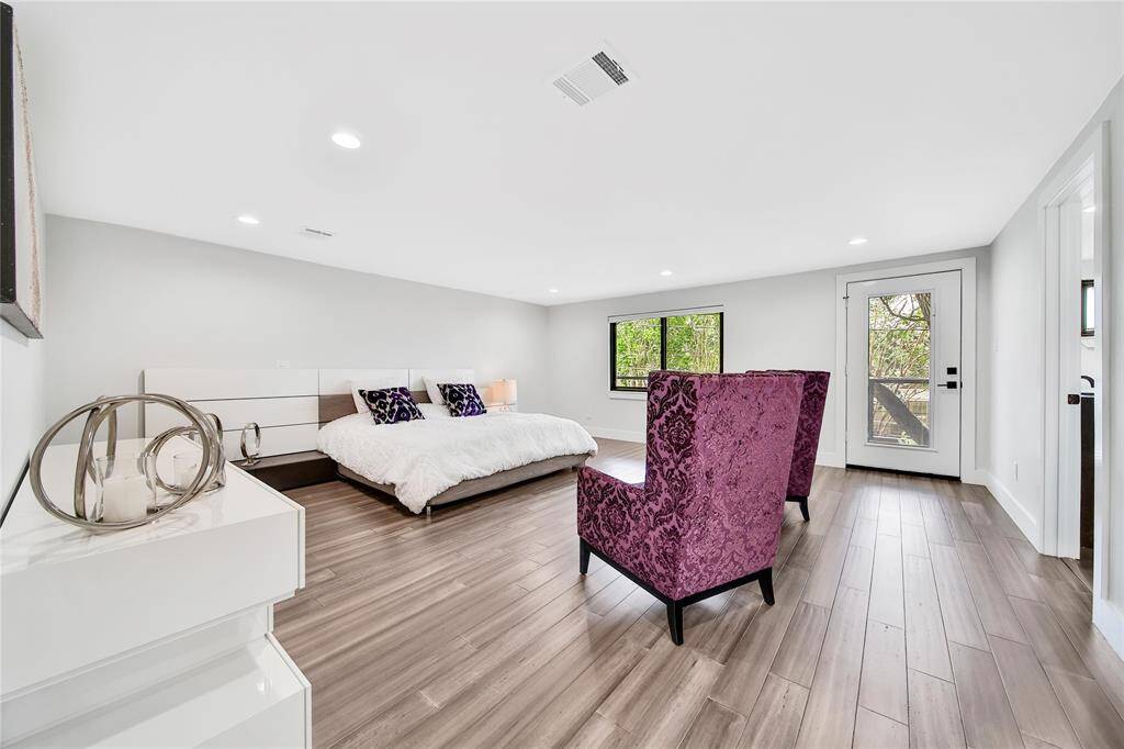 Upstairs primary suite with large walk-in closet and ensuite bathroom and balcony access.