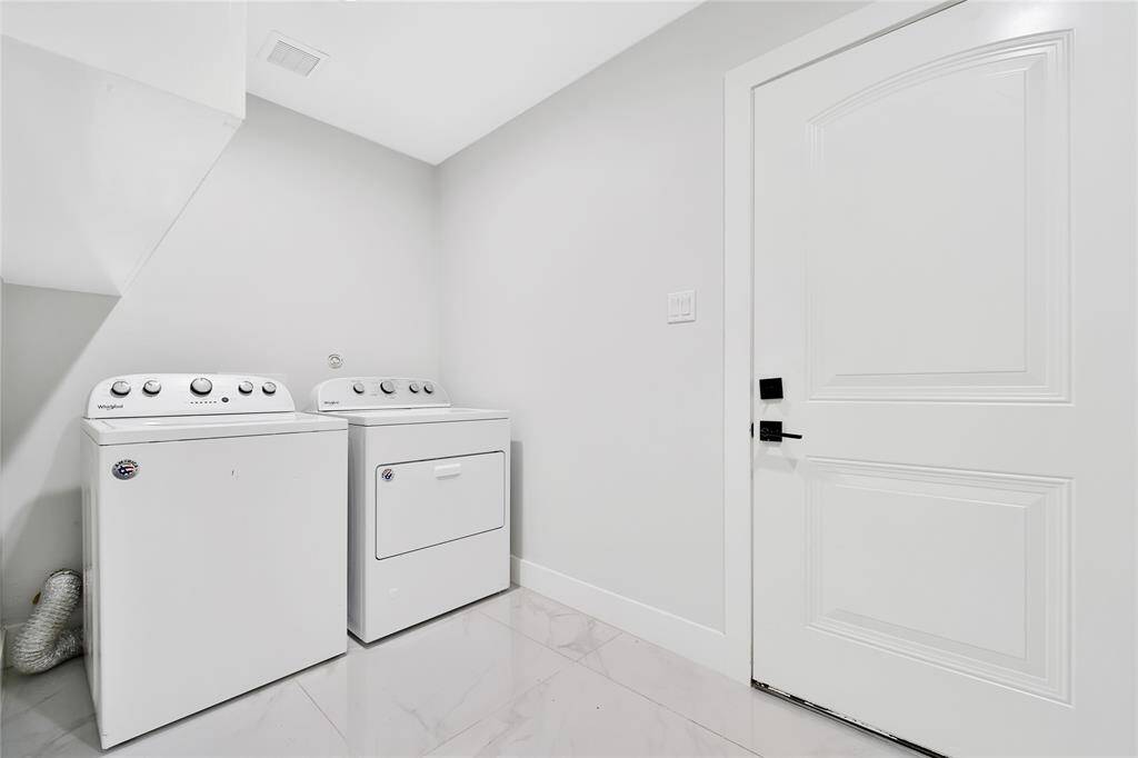 Downstairs laundry room located off the main living space leading to the attached garage.