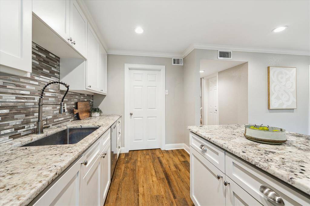 Tile mosaic backsplash, undermount sink, and plentiful prep space complete this well-appointed culinary space with seamless flow into the living areas.