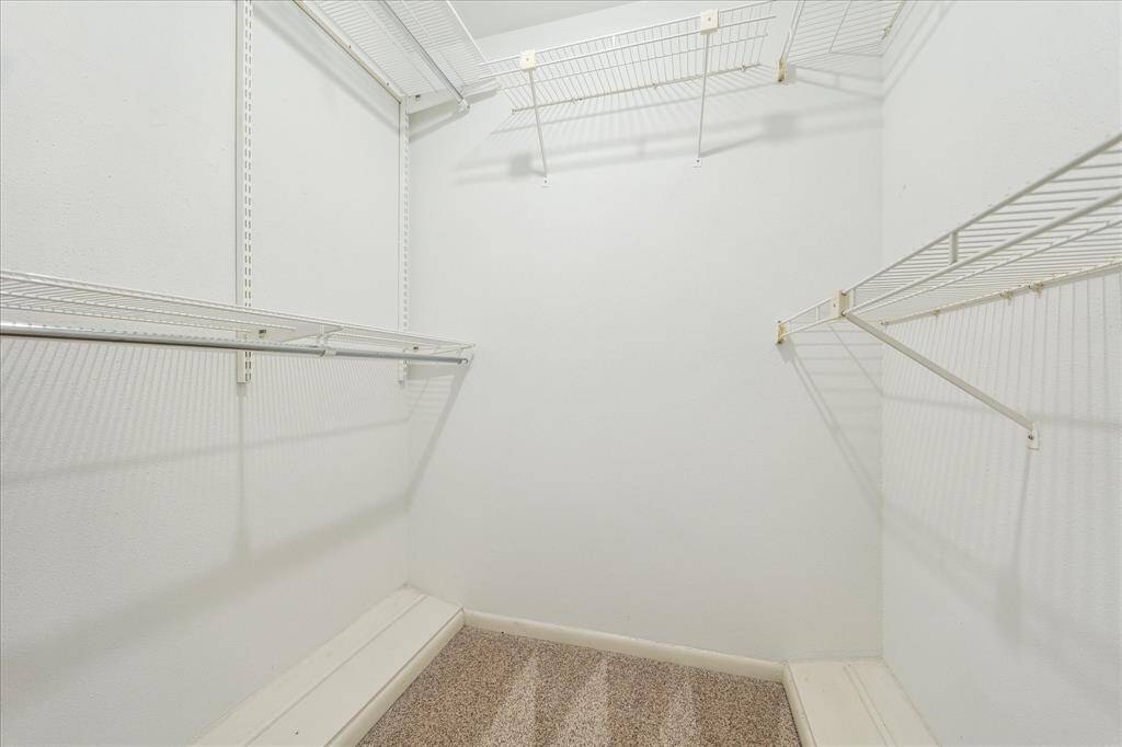 This oversized walk-in closet provides ample shelving and hanging space to keep everything neatly organized.