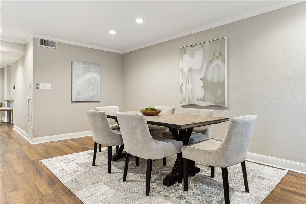 The formal dining area offers generous space for gatherings, accented by soft neutral tones and elegant crown molding.