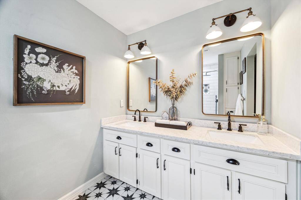 The primary bathroom features a double sink vanity with elegant marble countertops and ample cabinetry for all your storage needs.