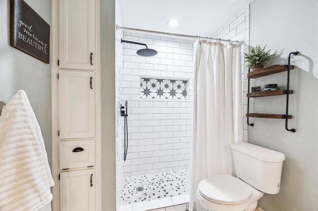 The primary bathroom features a spacious walk-in shower equipped with a rain showerhead.