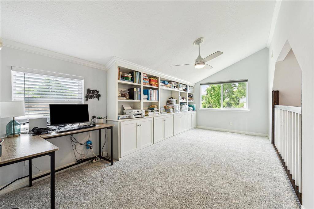 This spacious game room boasts wall-sized built-in shelves and cabinets, providing ample storage and display options for games, books, and entertainment essentials.