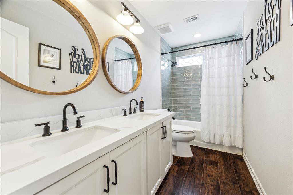 The upstairs secondary bathroom has been fully renovated, now featuring a double sink vanity and a new window that fills the space with natural light.