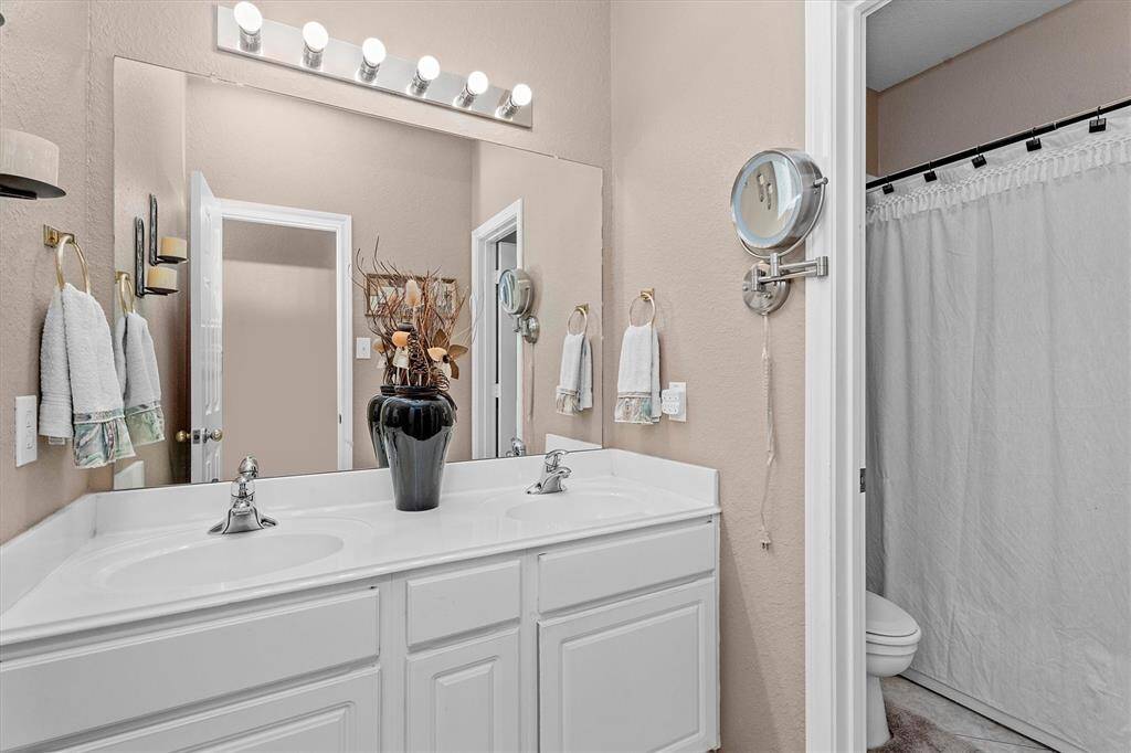 Secondary bathroom has double sinks and a separate shower/toilet room