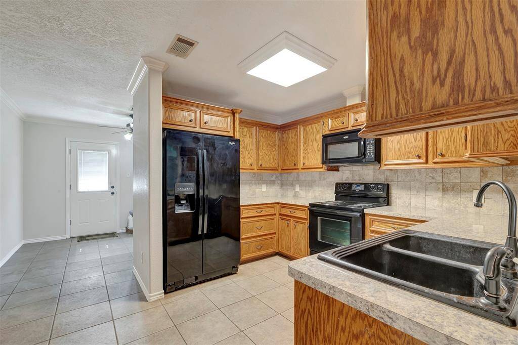From this corner of the kitchen, you get a partial view of the dining area and a second door that leads to the backyard.