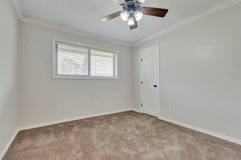 This secondary bedroom features carpeted floors and a spacious walk-in closet, tucked behind the closed door.