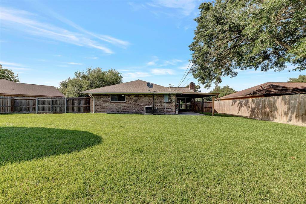 An additional view of the back of the house highlights the well-maintained backyard with its lush green grass.