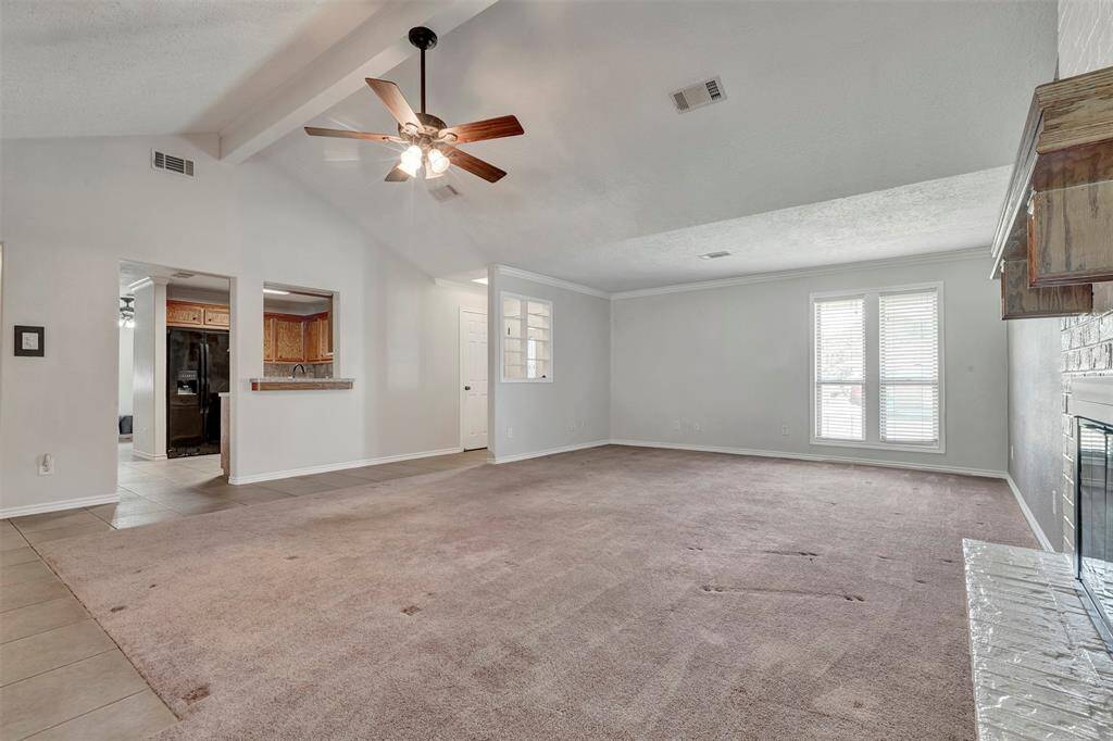 Another angle of the living room reveals a clear view of the foyer and the kitchen located just across the way, highlighting the home’s open layout.
