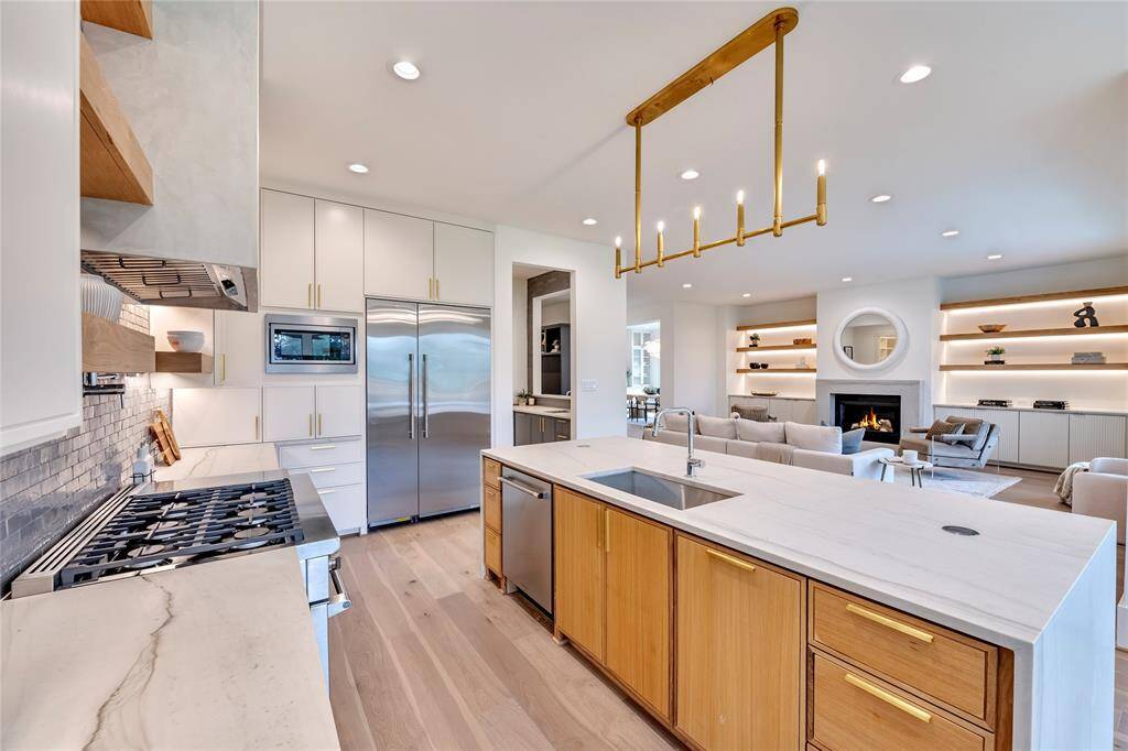 Previous construction custom touches like the lighted white oak shelving and custom fireplace surround make this home truly special.