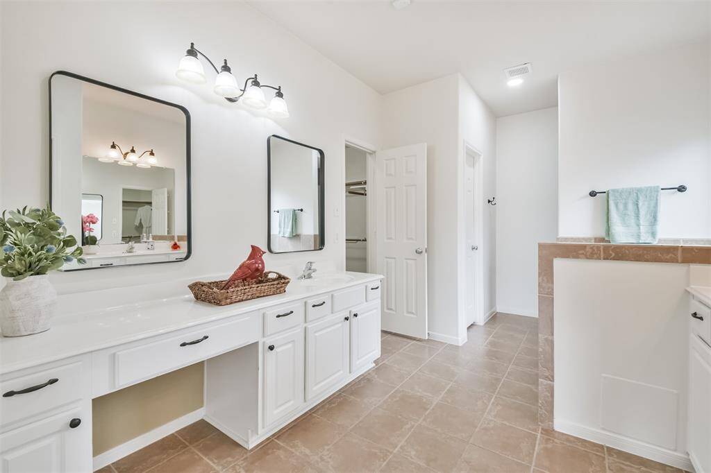 Primary bath has been updated with fresh paint, updated hardware and mirror. Features vanity area, 2 sinks, large tub, and private shower.