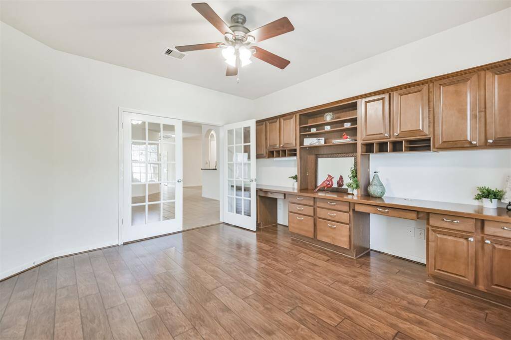 Private study with French doors and custom built-ins.