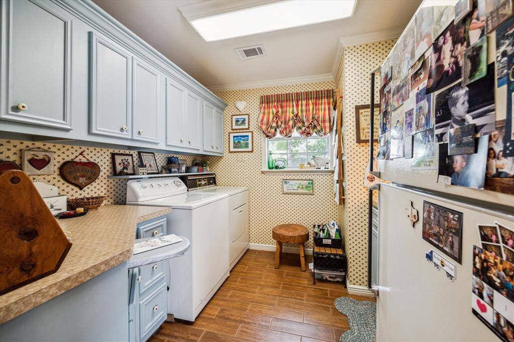 Convenience meets functionality in the utility room, which boasts additional storage, folding space, built-in ironing board, space for second fridge/freezer and a sink!