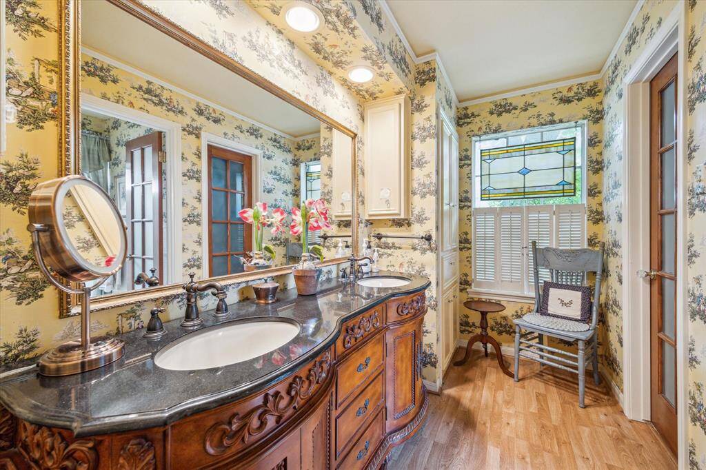 The primary bath offers a thoughtful and functional layout with a furniture-look vanity with granite countertops, double sinks, and an additional built-in storage cabinet providing both elegance and convenience. The separate wet area includes a tub/shower combination, offering versatility for daily routines. Two spacious walk-in closets complete this space, delivering ample storage and organization.