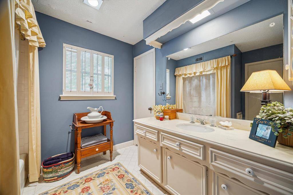 This well-designed upstairs bath is shared between two bedrooms and features a tub/shower combination and a spacious main vanity—perfect for making busy mornings a breeze. A second private vanity (not pictured) offers additional convenience, giving each bedroom its own dedicated space for added comfort and privacy.