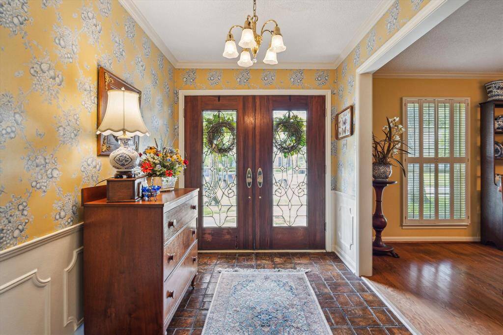 The formal entry, with its warm brick floors, opens gracefully to both the elegant formal dining room and the spacious family room. This home is a rare gem that combines comfort, charm, and a premier location—all in one unforgettable package.