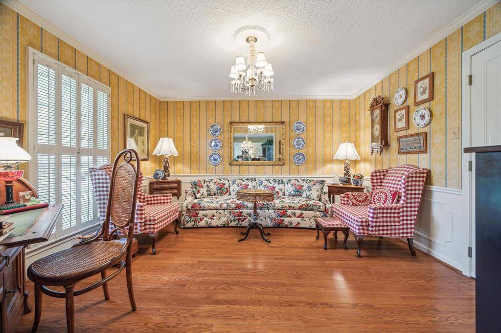 The formal living room is filled with natural light and charm, featuring shutters that frame views of the front yard. Thoughtfully designed for both comfort and functionality, this inviting space includes a convenient pass-through door to the kitchen and opens to the formal dining room—ideal for entertaining and everyday gatherings.