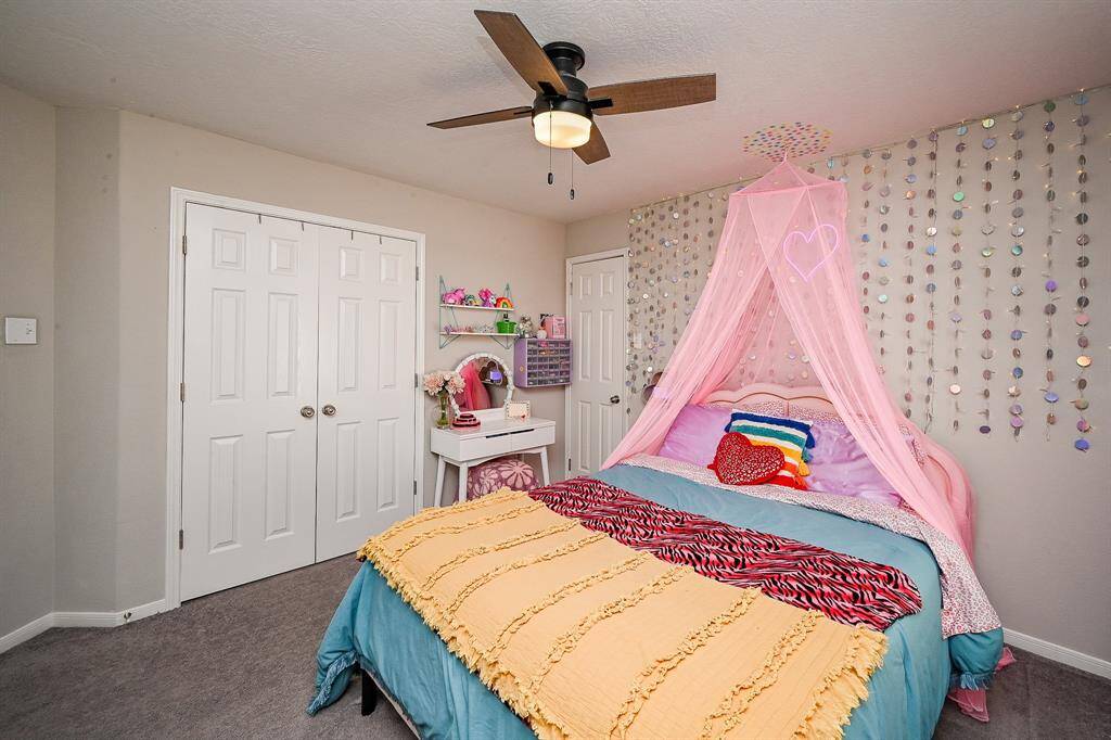 This cozy bedroom features ample storage with double closets. A ceiling fan provides comfort.