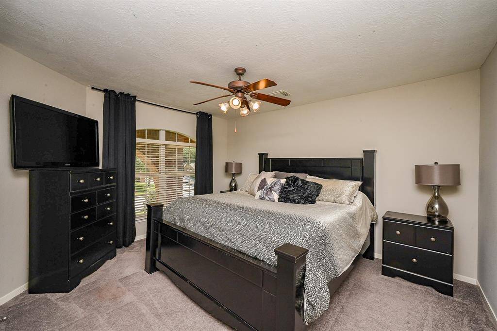 This bedroom features a spacious layout with a sizable window with curtains provides natural light.