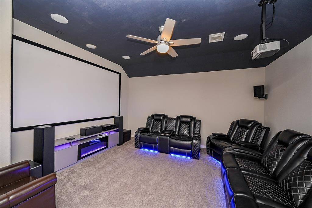 This photo showcases a modern home theater room. Ideal for movie nights, it offers a cozy and immersive entertainment experience.
