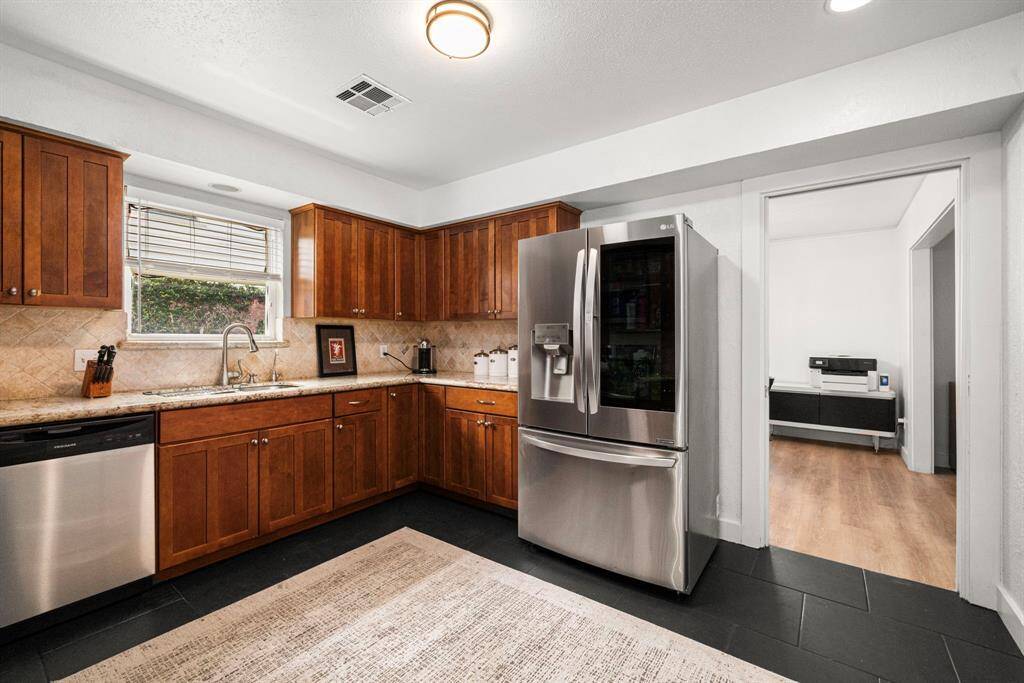 Kitchen features granite counters and tile backsplash.