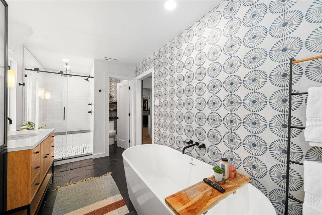 Primary bath features oversize shower with rain head, enclosed toilet