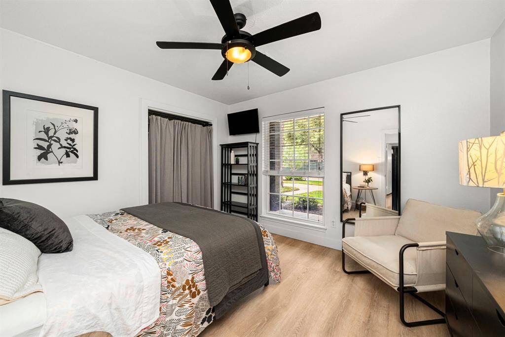Bedroom #2 has white oak luxury vinyl tile floors and neutral paint