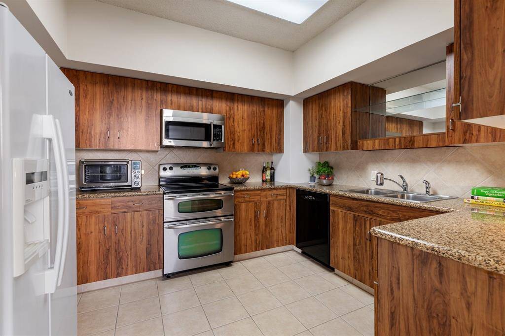 Kitchen with granite counters and tiled floors.