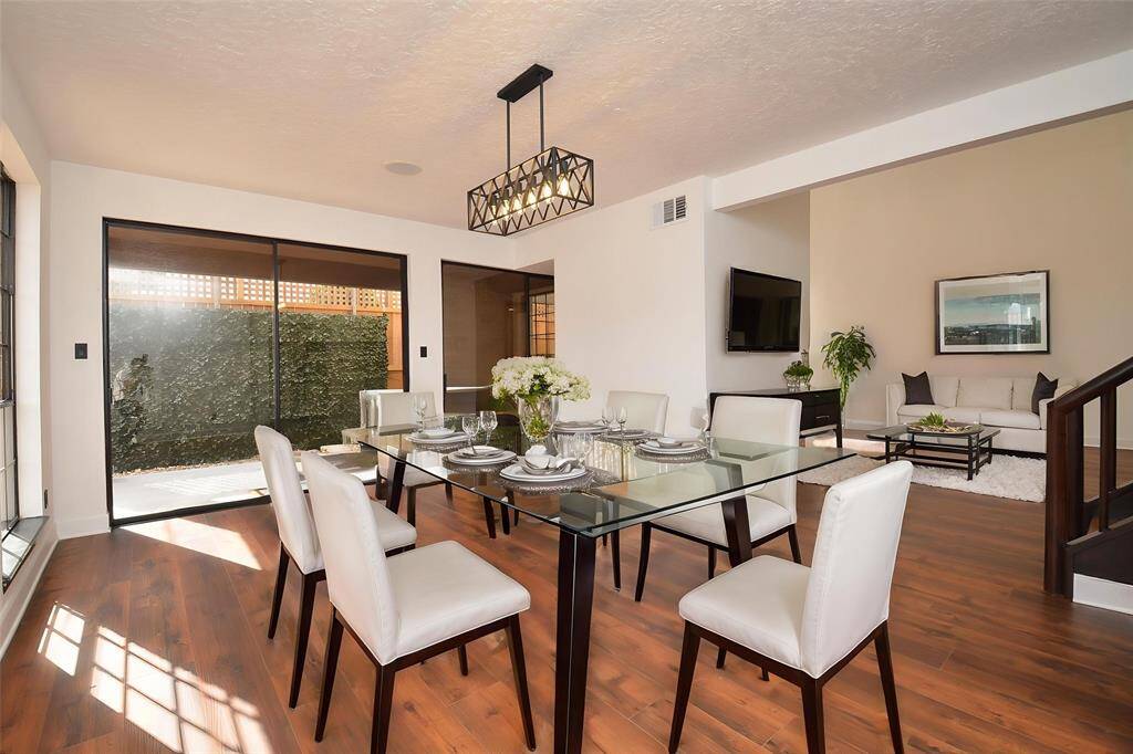 Formal dining room with plenty of natural lighting from large windows has been virtually staged.