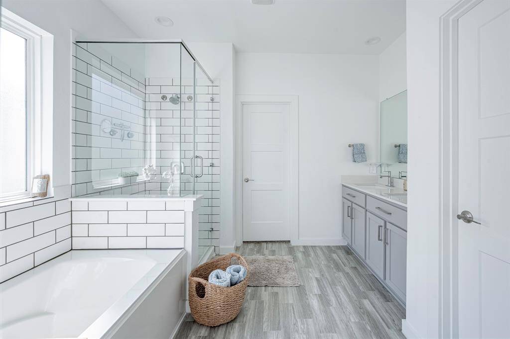 Luxurious primary bath featuring double vanities, soaking tub, and separate shower.