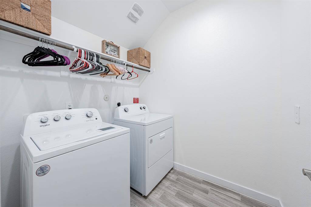 Dedicated laundry room with storage and a hanging rack keeps chores organized and tucked away.