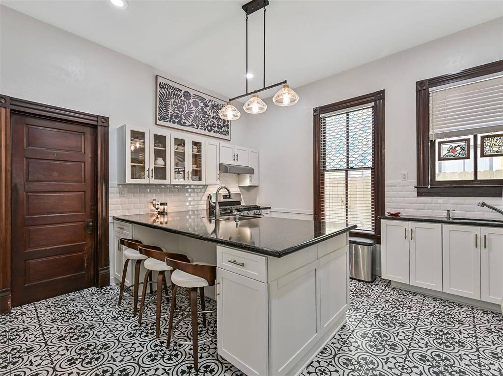 Updated kitchen with gorgeous tile and sleek granite counter tops. Convenient bar seating at the large island.