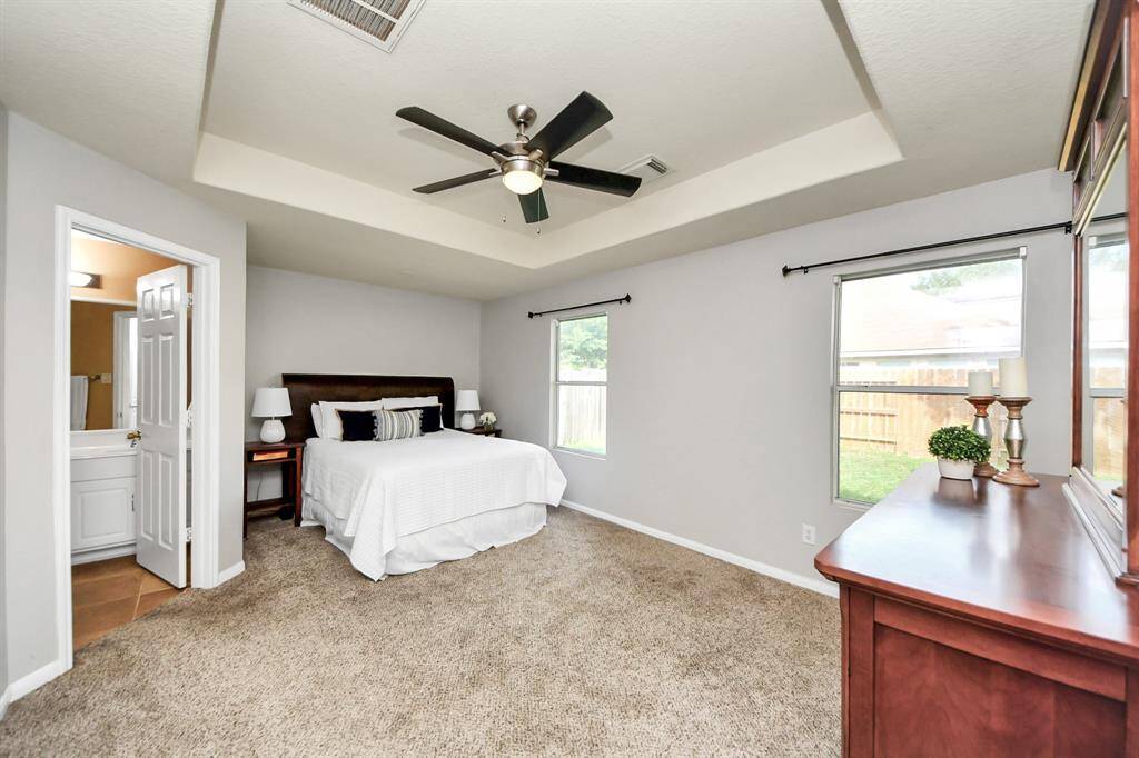 Retreat to the spacious primary bedroom featuring abundant natural light, soft neutral paint tones, and a serene atmosphere perfect for relaxation.