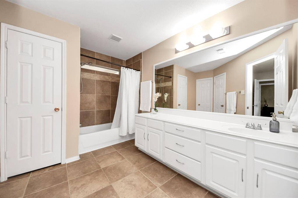 The ensuite bathroom offers both comfort and functionality with easy-to-maintain tile flooring.