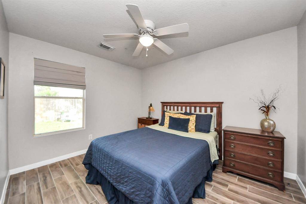 This bright and airy secondary bedroom features sleek tile flooring that offers durability and easy maintenance—perfect for guests or everyday living.