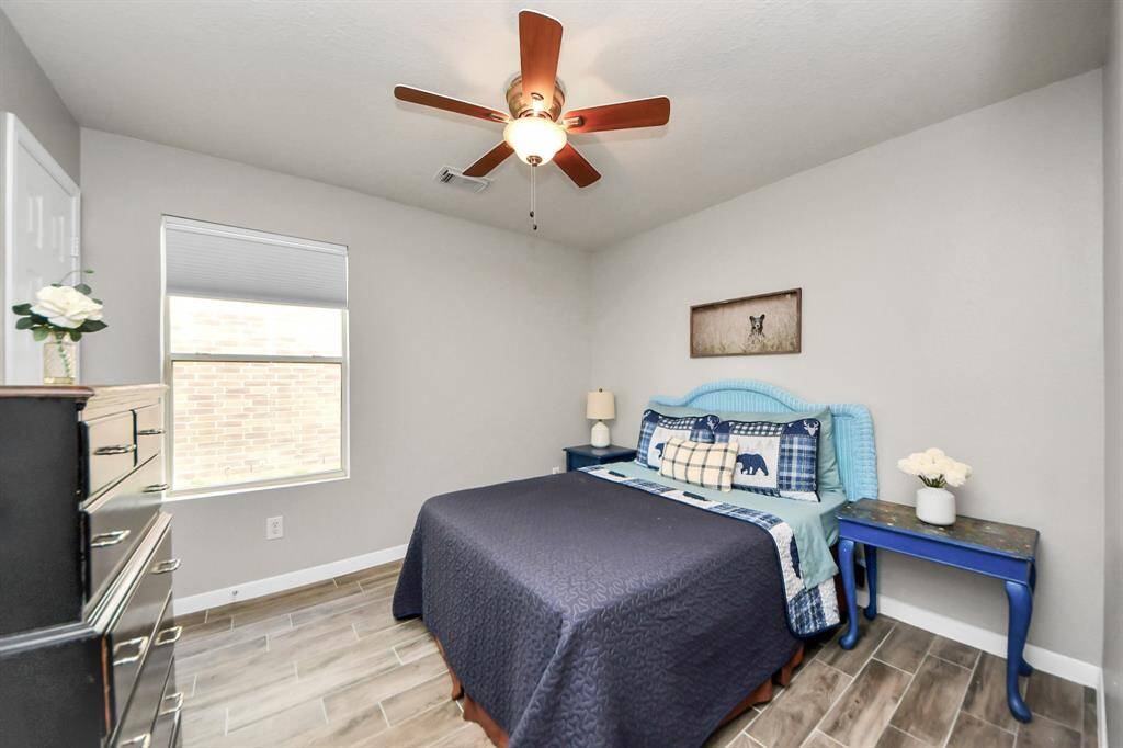 A large window brings in plenty of natural light to this bedroom, while neutral wall tones provide a versatile backdrop to suit any style.