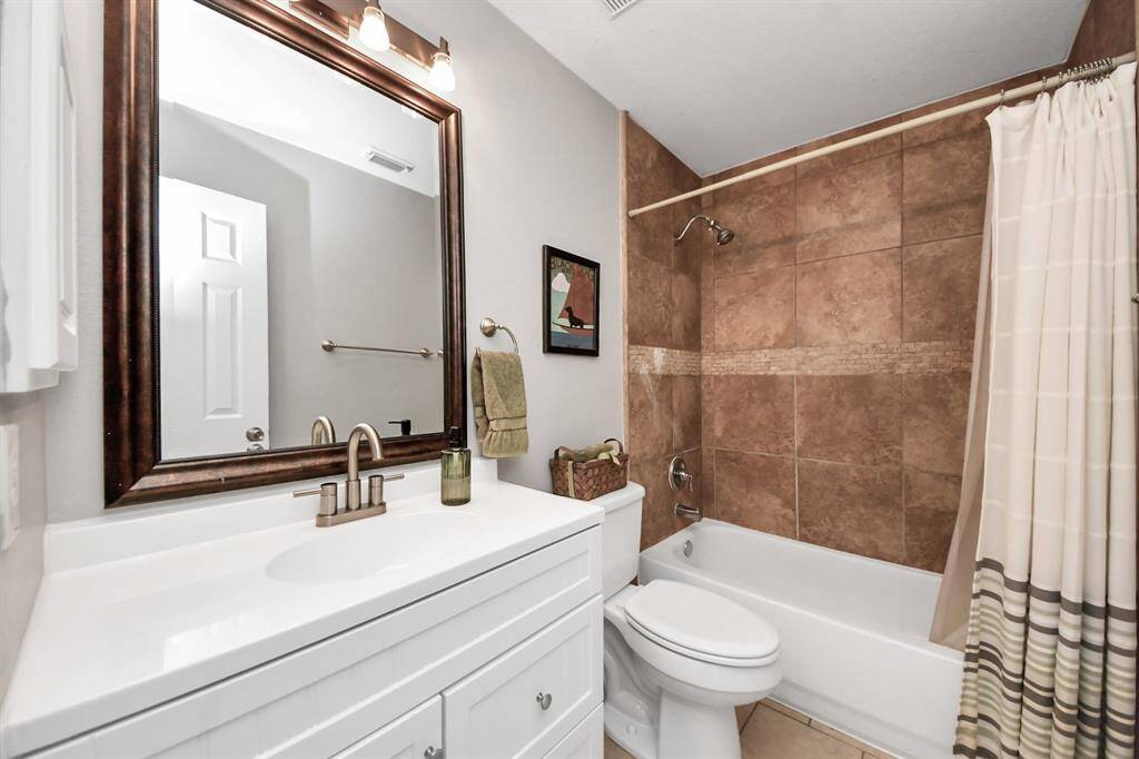 This well-appointed secondary full bathroom features a stylish tile shower and tub combination—ideal for both relaxing baths and quick showers.