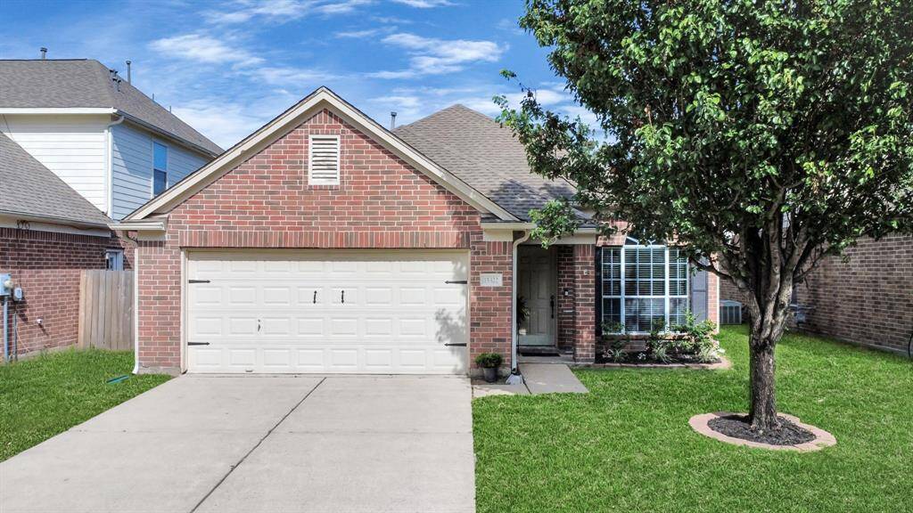This home offers a spacious front yard with a mature tree and manicured landscaping.
