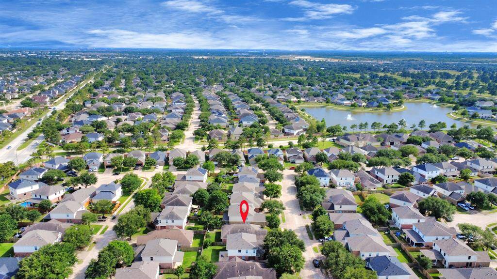 Aerial view showcasing the home's prime location in the desirable Villages of Cypress Lakes community. Nestled among tree-lined streets and surrounded by beautiful homes, this property offers close proximity to neighborhood amenities, scenic lakes, and walking trails.