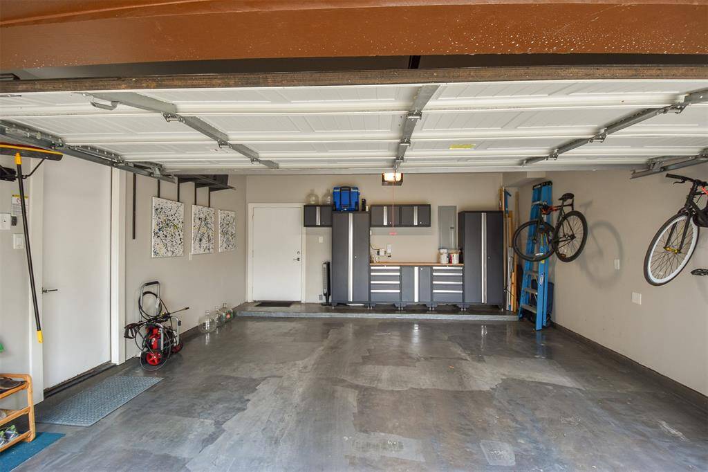 Garage has custom storage cabinets and leads out onto the backyard.